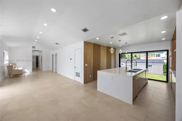a large white room with stainless steel appliances a large window