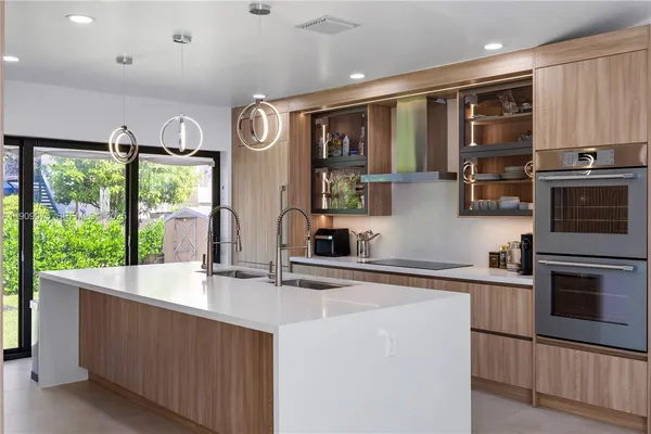 a living room with stainless steel appliances kitchen island granite countertop a sink and cabinets