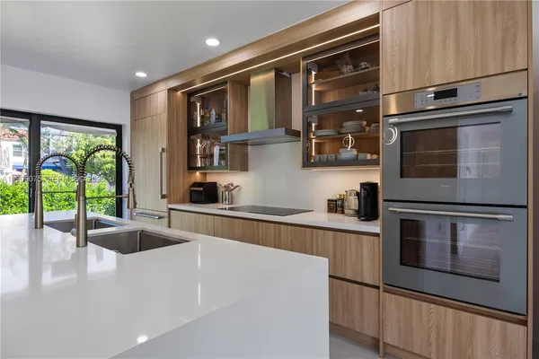a kitchen with stainless steel appliances a stove microwave and sink