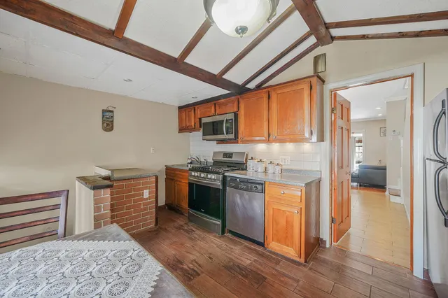 a kitchen with stainless steel appliances granite countertop a stove a sink and a refrigerator