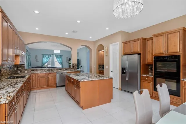 a large kitchen with stainless steel appliances kitchen island granite countertop a large counter top and stainless steel appliances