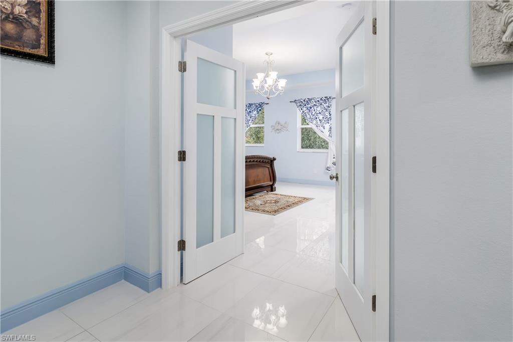 2181 Vardin Place Naples, FL 34120 - Photo 20 of 37 a view of a hallway with wooden floor and a bathroom