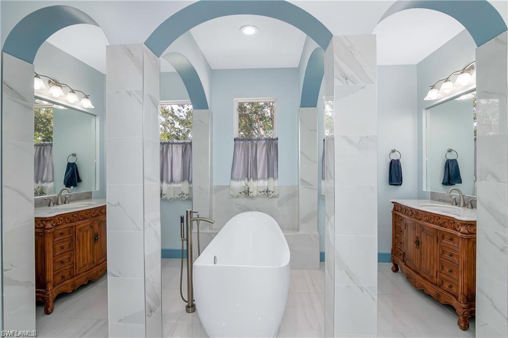 2181 Vardin Place Naples, FL 34120 - Photo 23 of 37 a bathroom with a sink a mirror and a shower