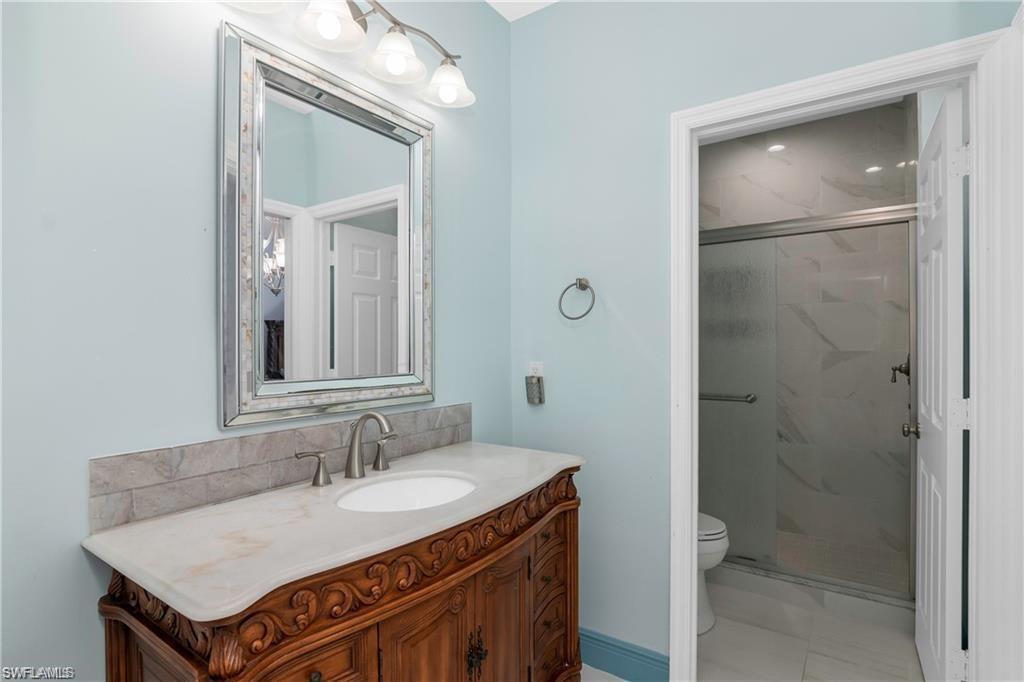 2181 Vardin Place Naples, FL 34120 - Photo 25 of 37 a bathroom with a sink and a mirror