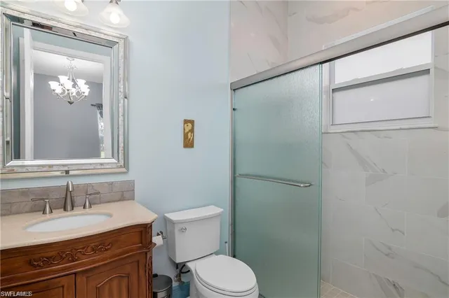 a bathroom with a sink a toilet a mirror and shower