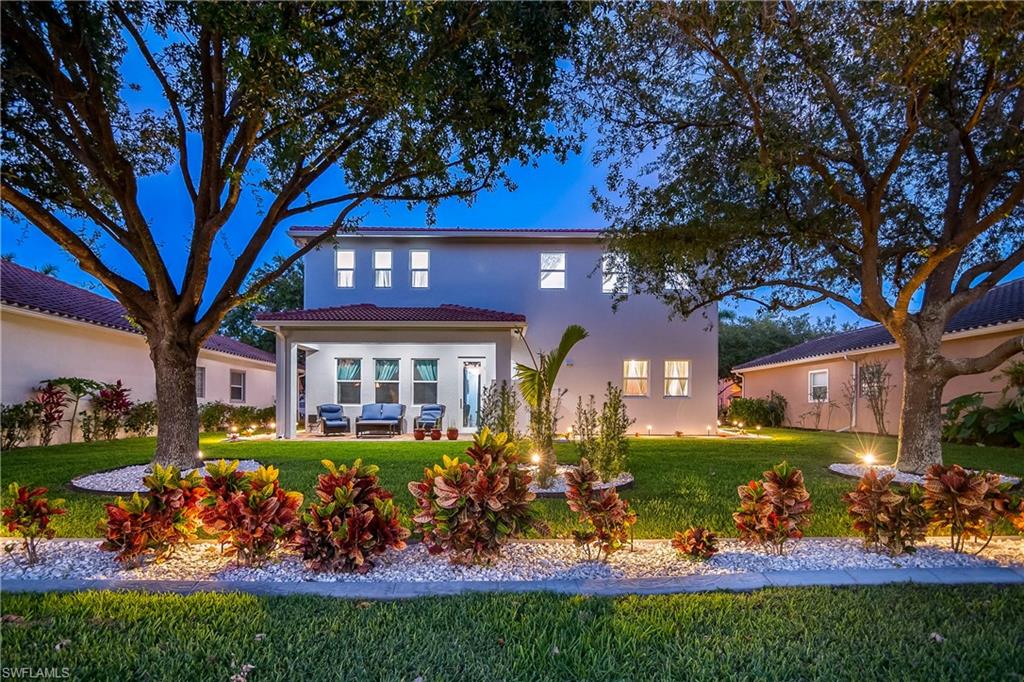 2181 Vardin Place Naples, FL 34120 - Photo 34 of 37 a view of a house with large trees and a yard