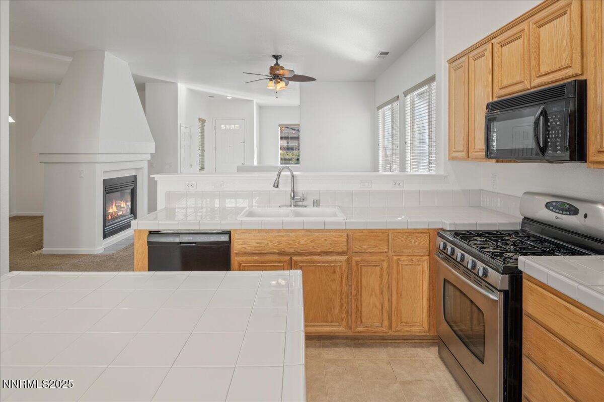 10583 Crystal Bay Drive Reno, NV 89521 - Photo 15 of 43 a kitchen with stainless steel appliances granite countertop a stove sink and cabinets