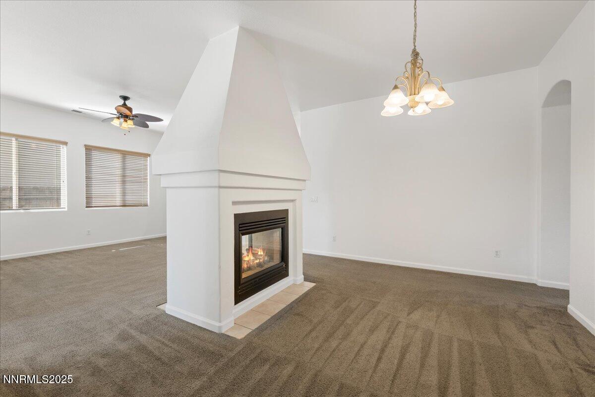 10583 Crystal Bay Drive Reno, NV 89521 - Photo 18 of 43 a view of a livingroom with a fireplace a chandelier and windows