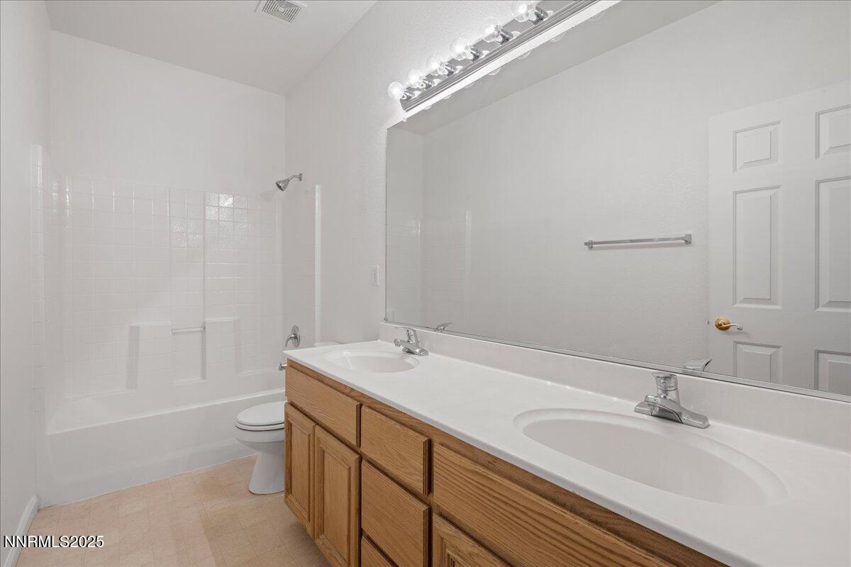 10583 Crystal Bay Drive Reno, NV 89521 - Photo 31 of 43 a bathroom with a sink a toilet and a large mirror