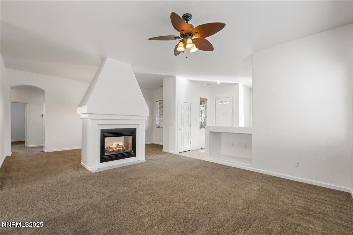 10583 Crystal Bay Drive Reno, NV 89521 - Photo 10 of 43 an empty room with a fireplace and a ceiling fan