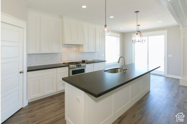 1447 North 1350 E Street, Unit 5 Mapleton, UT 84664 - Photo 8 of 10 Kitchen featuring white cabinetry, an island with sink, backsplash, gas stove, and dark wood-type flooring