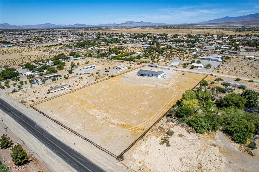 5910 East Kellogg Road Pahrump, NV 89061 - Photo 52 of 58 A desert landscape unfolds with a modern house nestled on a vast, undeveloped lot.