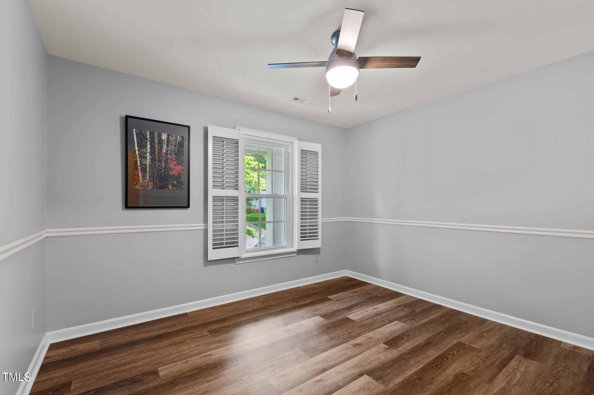 8116 Coleraine Court Raleigh, NC 27615 - Photo 42 of 58 an empty room with a window and ceiling fan
