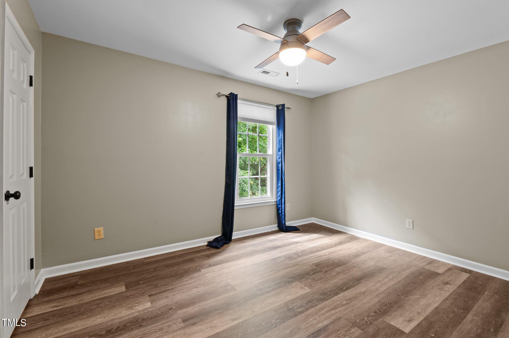 8116 Coleraine Court Raleigh, NC 27615 - Photo 43 of 58 an empty room with wooden floor and windows