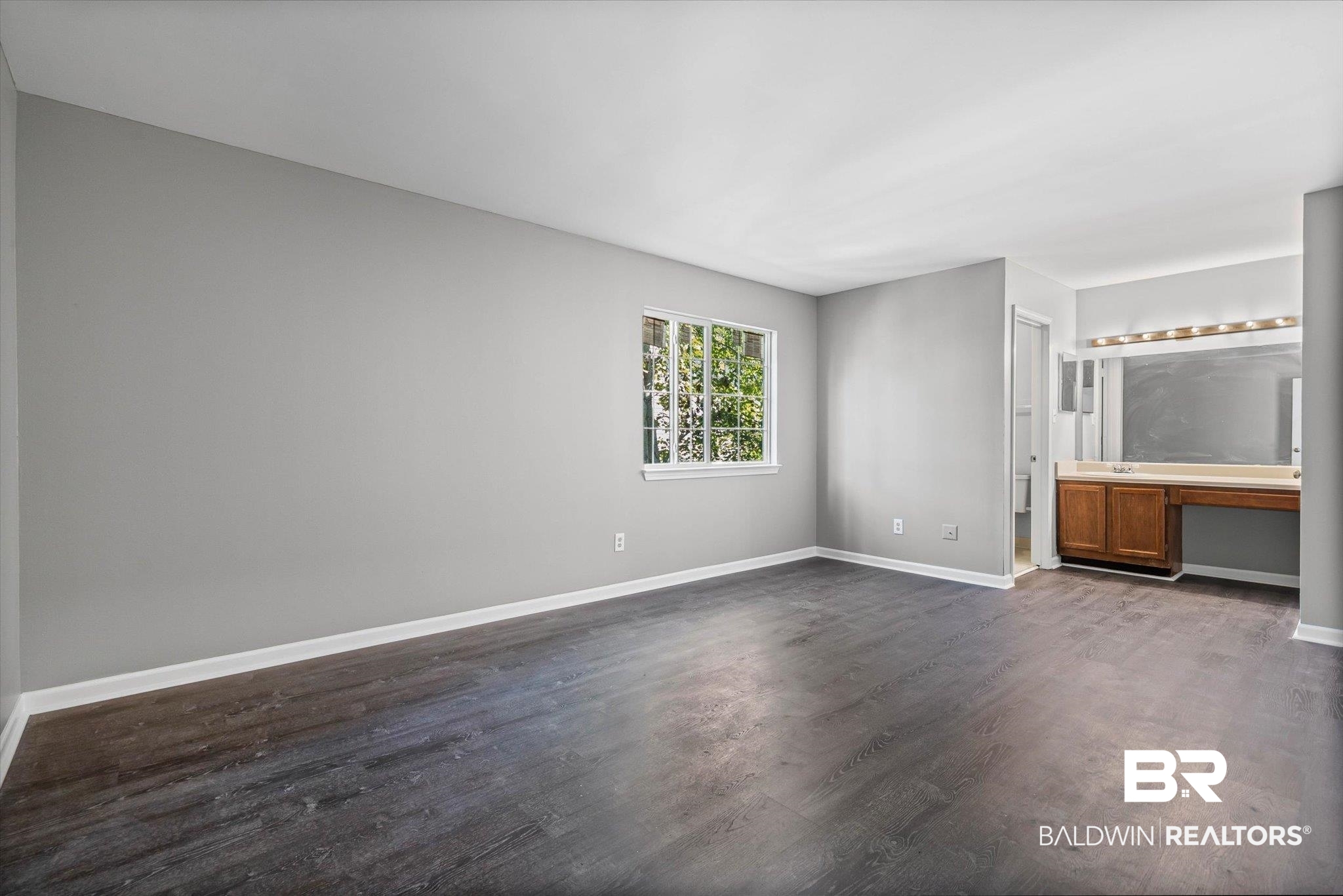 6701 Dickens Ferry Road, Unit 100 Mobile, AL 36608 - Photo 13 of 24 Unfurnished bedroom featuring dark wood-type flooring and built in desk