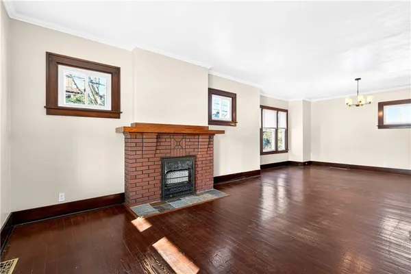 a view of empty room with fireplace and wooden floor