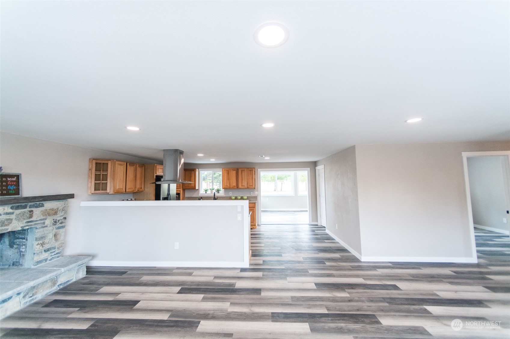 4820 176th Avenue Southwest Rochester, WA 98579 - Photo 13 of 40 a living room with kitchen island furniture and a wooden floor