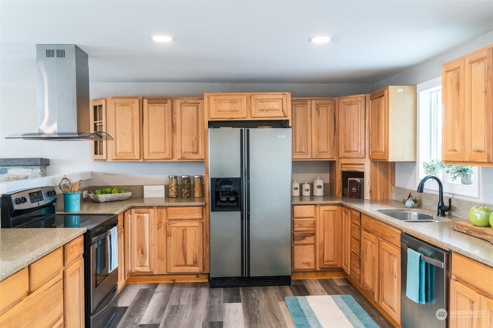4820 176th Avenue Southwest Rochester, WA 98579 - Photo 7 of 40 a kitchen with stainless steel appliances granite countertop a refrigerator a sink dishwasher and wooden cabinets with wooden floor