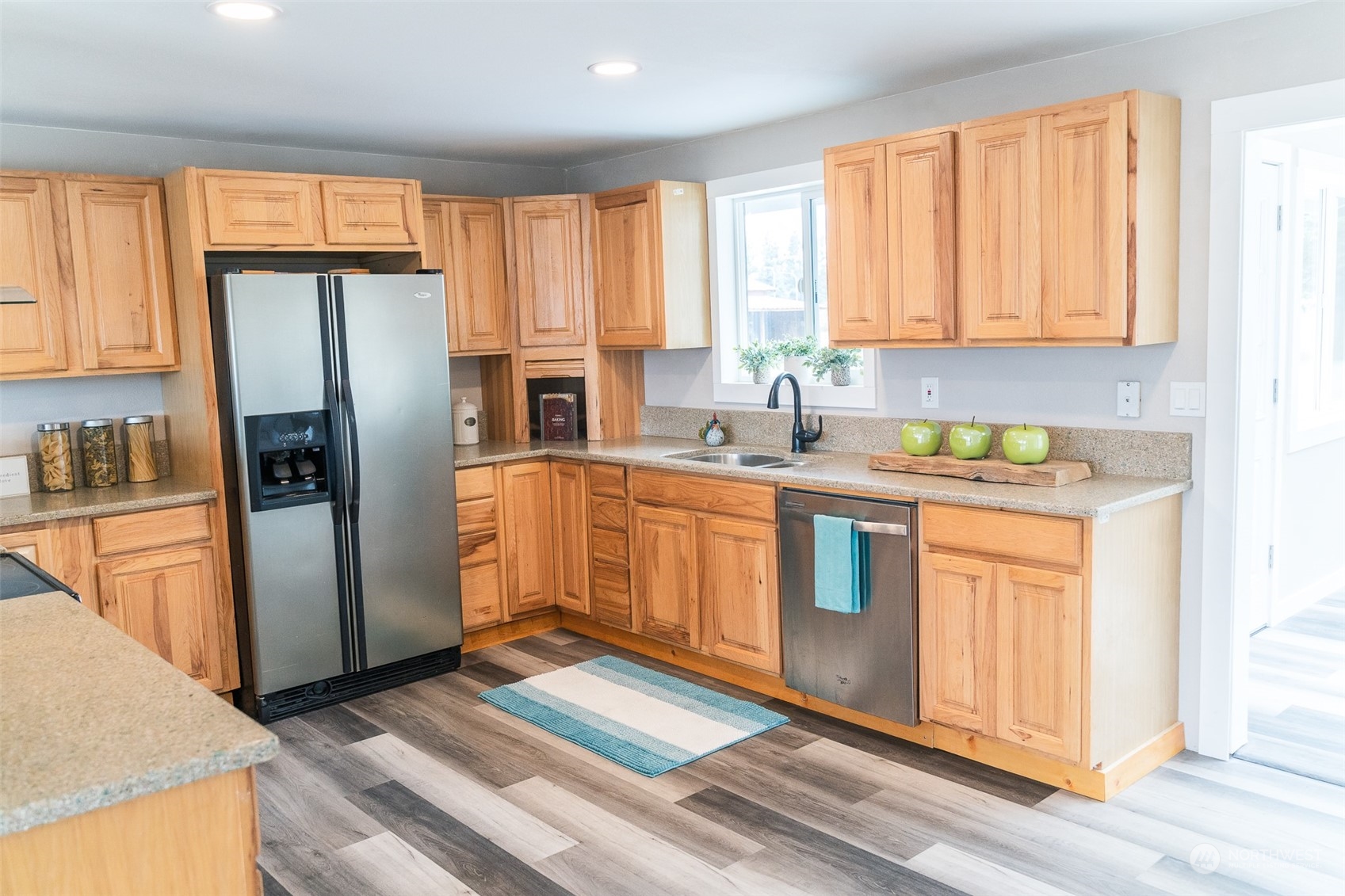 4820 176th Avenue Southwest Rochester, WA 98579 - Photo 9 of 40 a kitchen with stainless steel appliances granite countertop a refrigerator a sink dishwasher and wooden cabinets with wooden floor