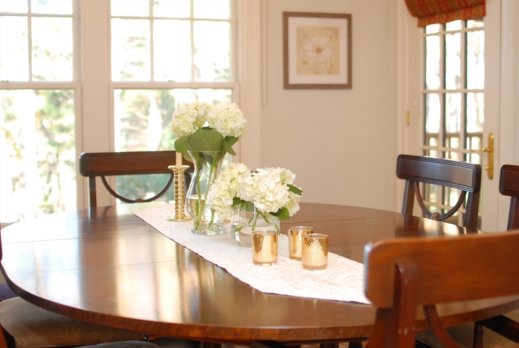 96 Forest Ridge Road, Unit 96 Concord, MA 01742 - Photo 15 of 36 a view of a dining room with furniture a potted plant and wooden floor