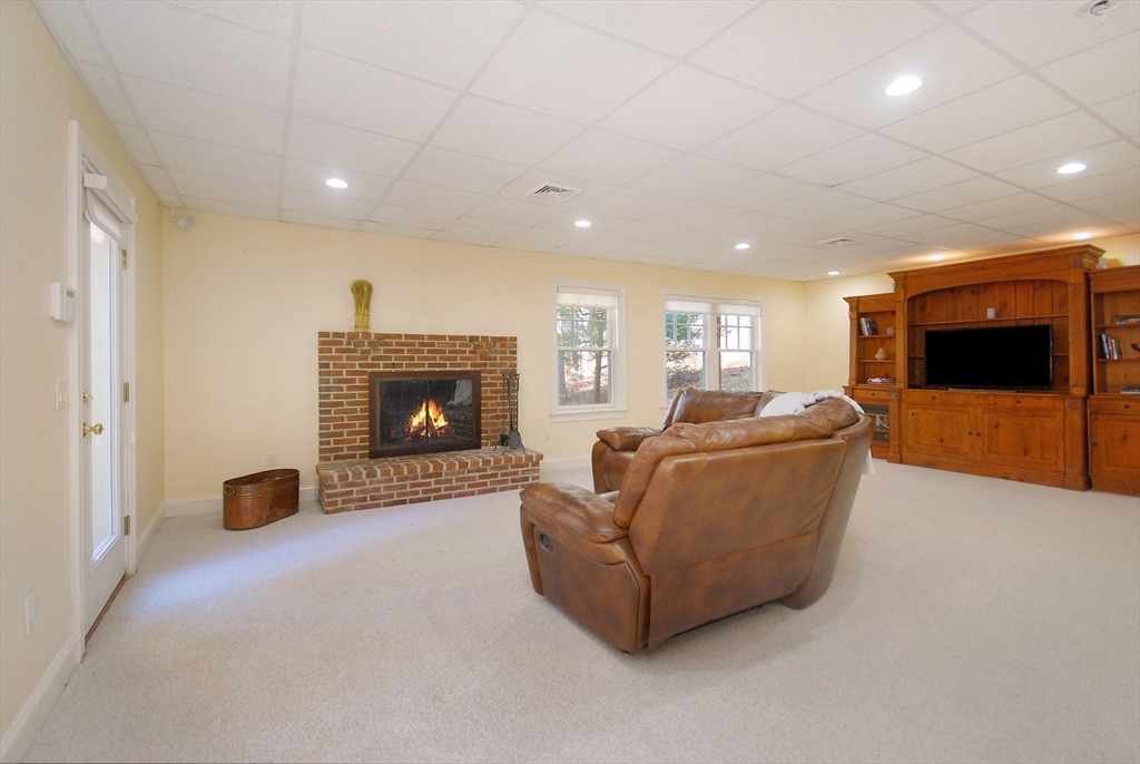 96 Forest Ridge Road, Unit 96 Concord, MA 01742 - Photo 28 of 36 a living room with furniture and a fireplace