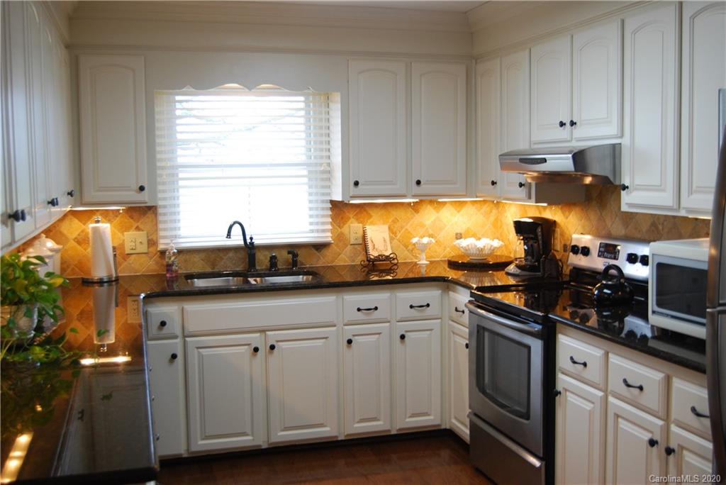 2716 Stack Road Monroe, NC 28112 - Photo 9 of 42 a kitchen with white cabinets and sink