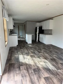 a view of a kitchen with refrigerator and white cabinets