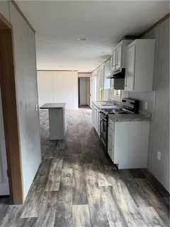 a kitchen with granite countertop a sink stove and refrigerator