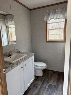 a bathroom with a granite countertop sink toilet and mirror