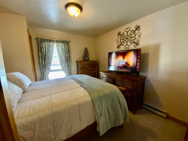 a bedroom with a bed and a flat screen tv