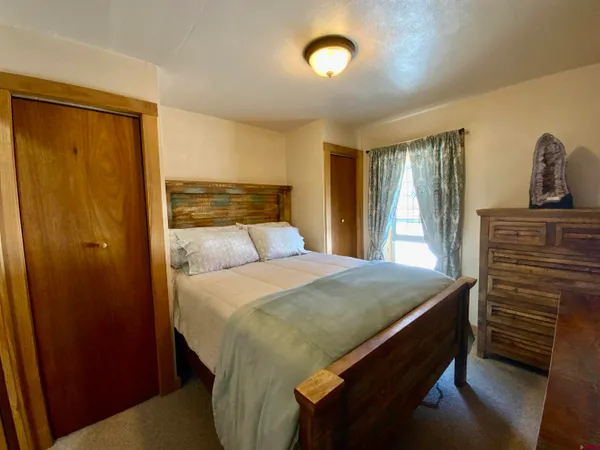 a bedroom with a bed and large windows