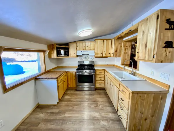 a large kitchen with stainless steel appliances granite countertop a stove and a sink