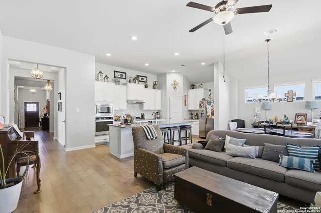 a living room with furniture and a view of kitchen