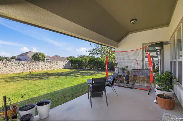 a view of a patio with lawn chairs plants and swimming pool