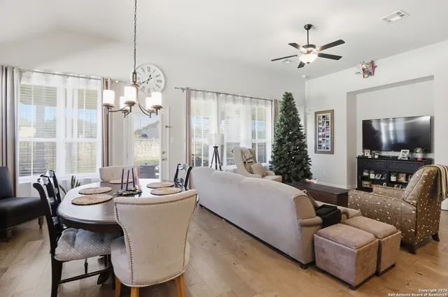 a living room with furniture a chandelier and a flat screen tv