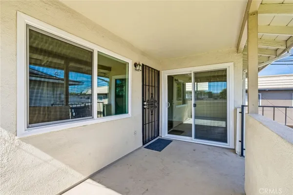 a view of an empty room with a floor to ceiling window and wooden floor