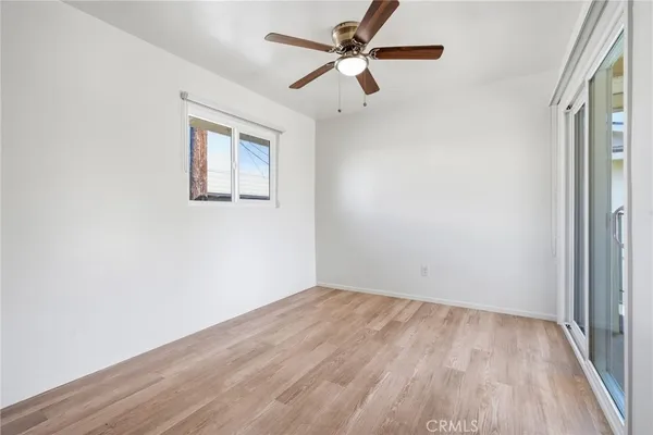 an empty room with a window and a ceiling fan