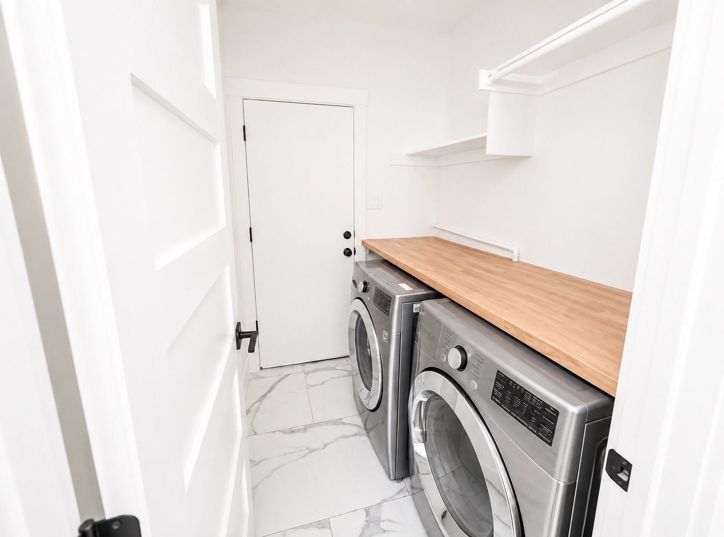 1610 Juniper Ridge Loop Cedar Park, TX 78613 - Photo 26 of 28 An organized laundry room features modern tile flooring, built-in shelving, and a wood countertop.