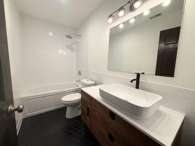 a bathroom with a double vanity sink toilet and shower