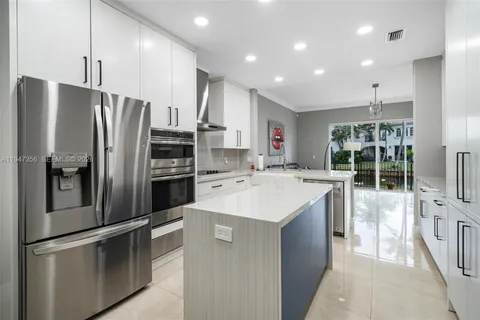 a kitchen with kitchen island a sink appliances and cabinets