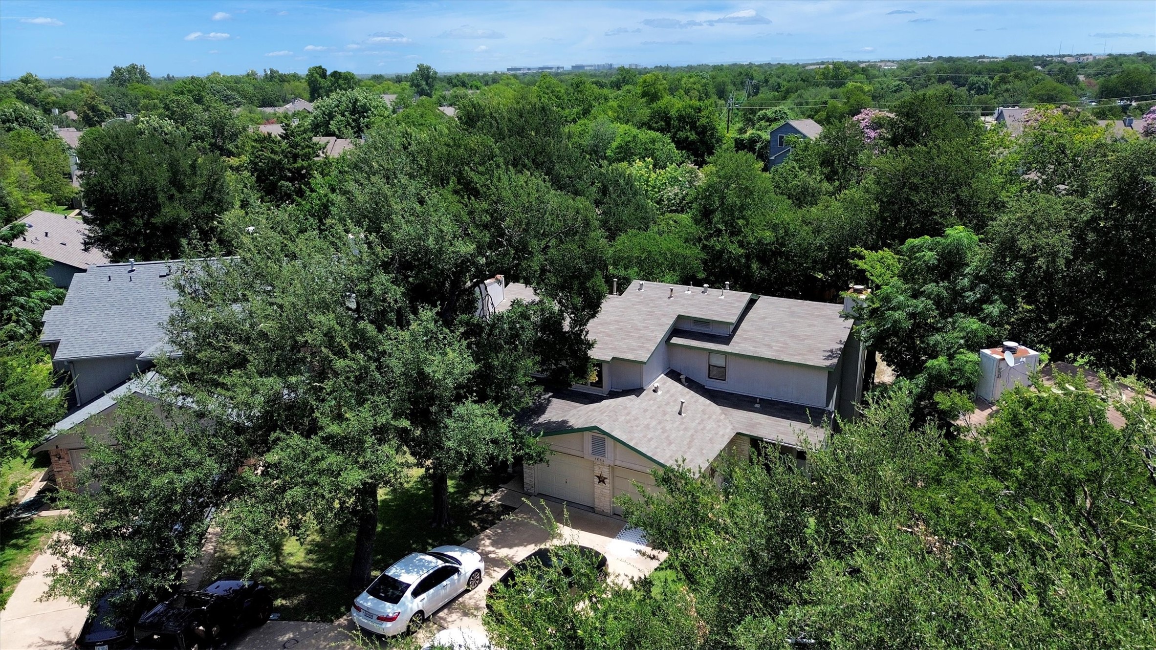 7802 Topawa Cove, Unit B Austin, TX 78729 - Photo 27 of 32 An aerial perspective showcases the inviting roofline and lush tree canopy of this charming residence.