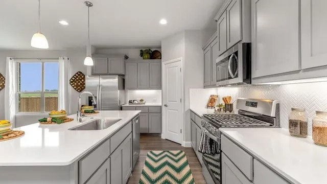 a kitchen with granite countertop a center island stainless steel appliances and cabinets