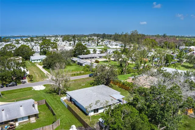 an aerial view of residential houses with outdoor space and trees