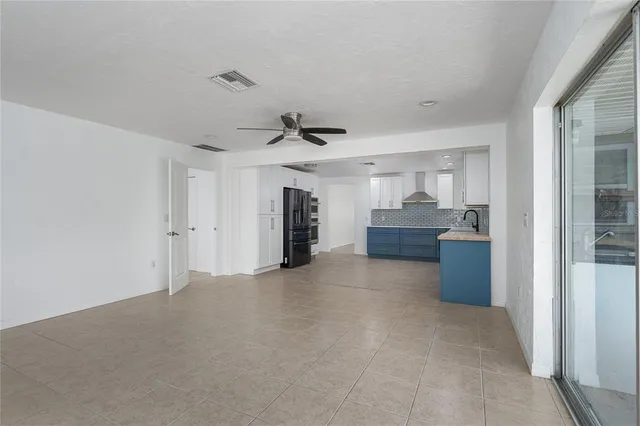 a view of a kitchen with refrigerator and windows