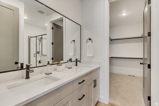1389 1440 East, Unit 1 Payson, UT 84651 - Photo 10 of 17 Double vanity with integrated sinks, light-toned countertop, and matte black fixtures