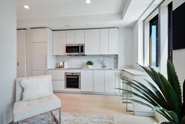 a kitchen with stainless steel appliances cabinets a sink and a microwave