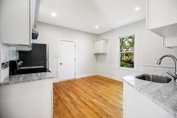 348 Centre Street, Unit 3 Boston, MA 02130 - Photo 12 of 17 a bedroom with a granite countertop white cabinets and a sink