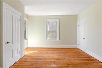 348 Centre Street, Unit 3 Boston, MA 02130 - Photo 7 of 17 a view of an empty room with wooden floor and a window