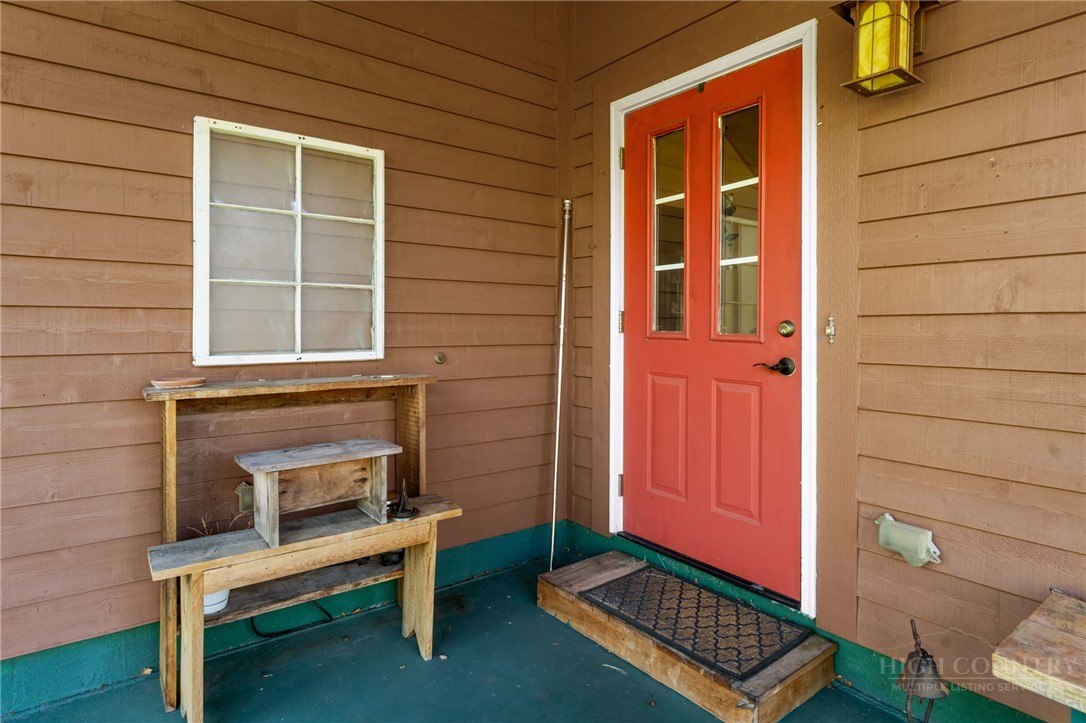 143 Lena Way Jefferson, NC 28640 - Photo 30 of 38 a door and a chair in a room with wooden floor and a door