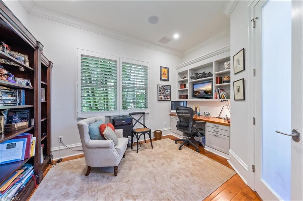 18051 Lagos Way Naples, FL 34110 - Photo 15 of 26 a living room with furniture a rug and a book shelf